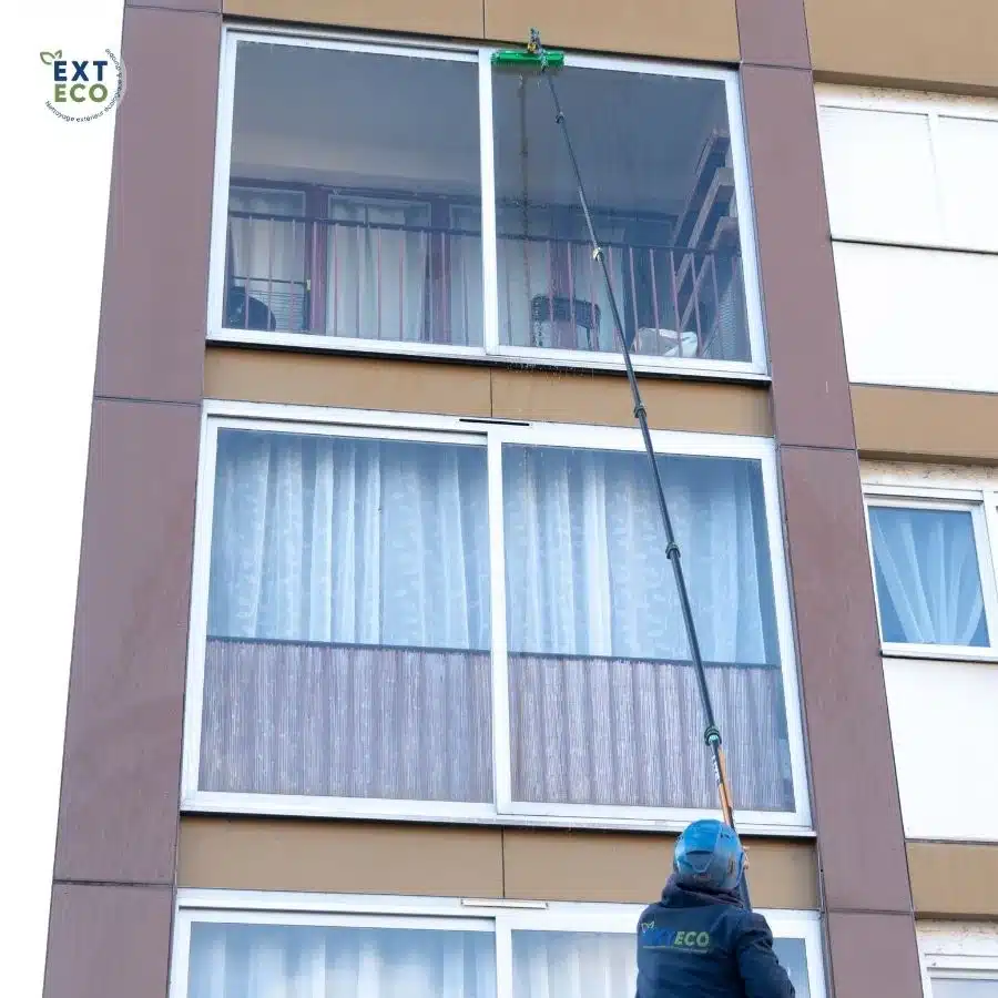 techinicien qui nettoie des vitres en hauteur à l'eau pure
