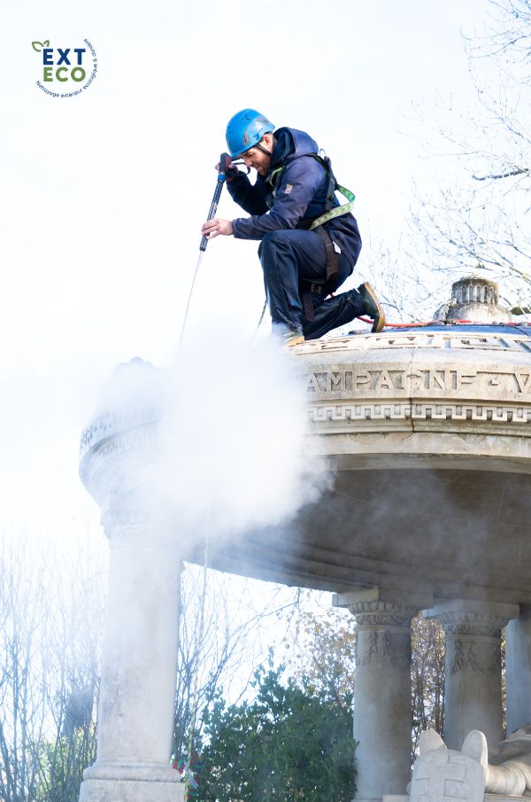 Technicien exteco sur le monument aux morts qui nettoie à la vapeur basse pression le support